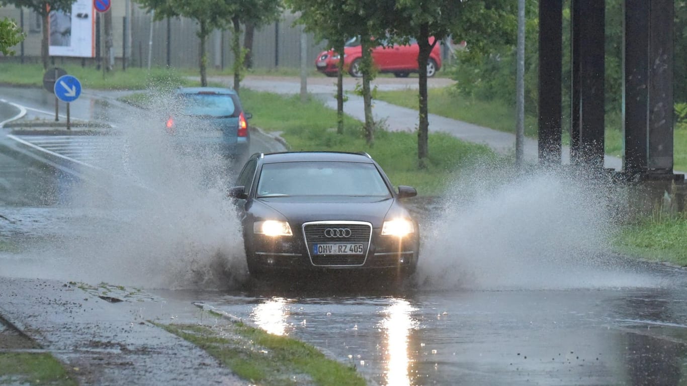 Autos fahren durch vom Regen überspülte Straßen in Oranienburg (Brandenburg).