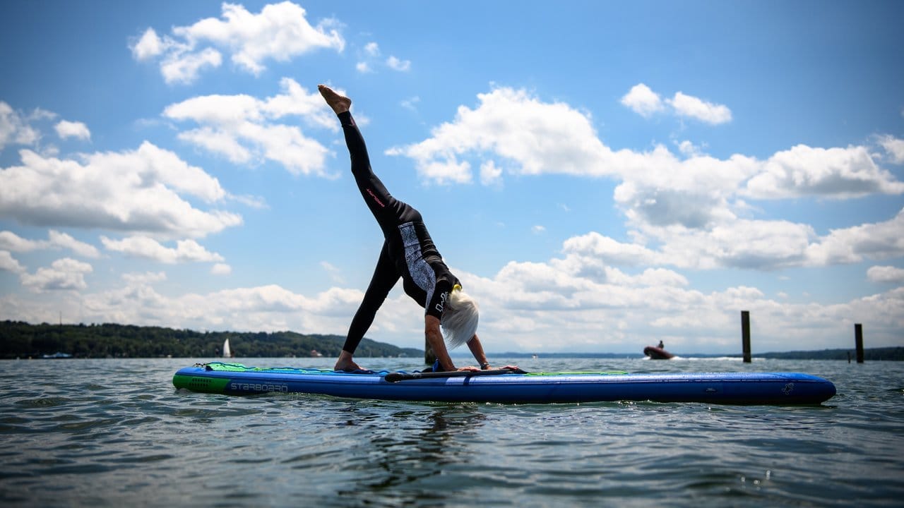 Die 79-jährige Elisabeth Rösel macht Yoga-Übungen beim Stand Up Paddling auf dem Starnberger See.
