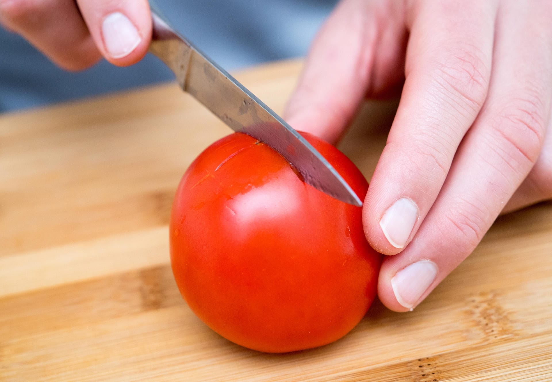 1. Mit einem Messer die Tomate auf der Unterseite kreuzweise einritzen.