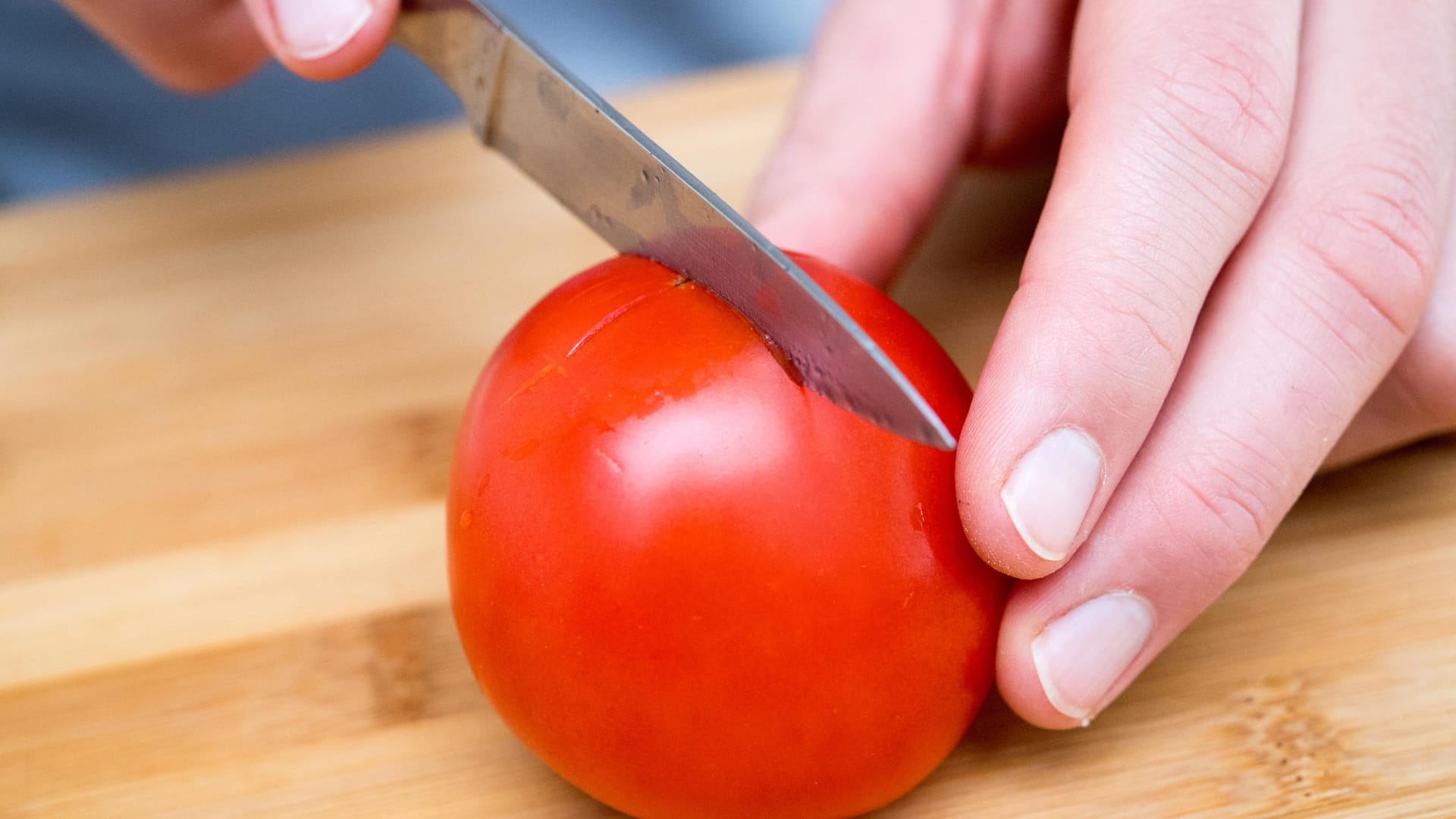 1. Mit einem Messer die Tomate auf der Unterseite kreuzweise einritzen.