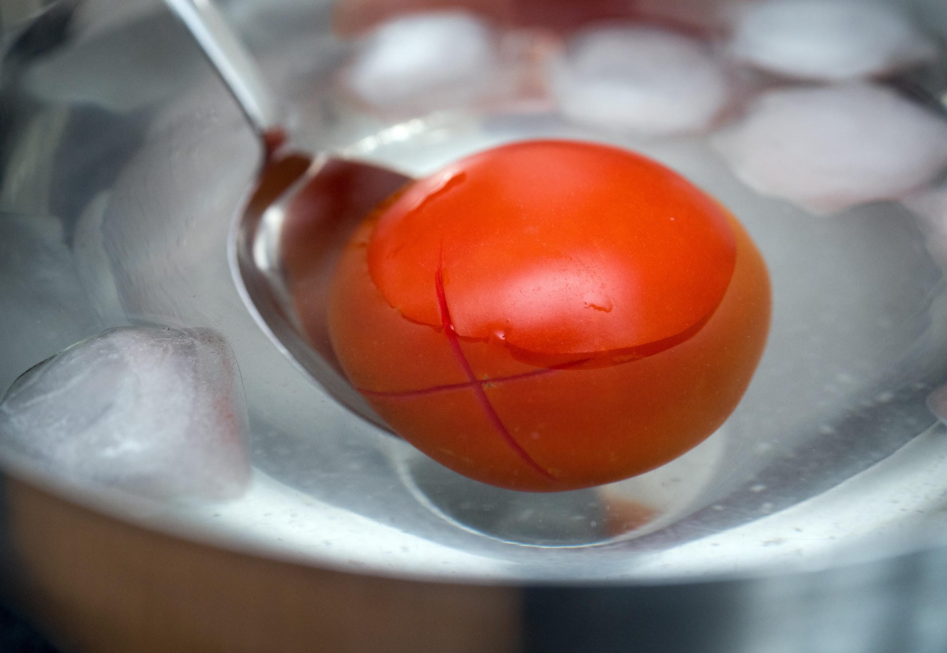 3. Die Tomate mit einem Löffel in eine Schale mit Eiswasser geben.