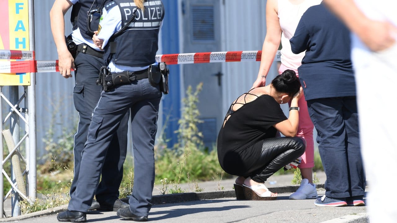 Eine Frau hockt neben einer Seelsorgerin und Polizisten vor der Diskothek. Eine Frau hockt neben einer Seelsorgerin und Polizisten vor der Diskothek.