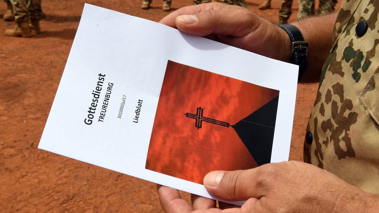 Ein Soldat hält beim Feldgottesdienst im Camp Castor ein Liedblatt in der Hand. Ein Soldat hält beim Feldgottesdienst im Camp Castor ein Liedblatt in der Hand.