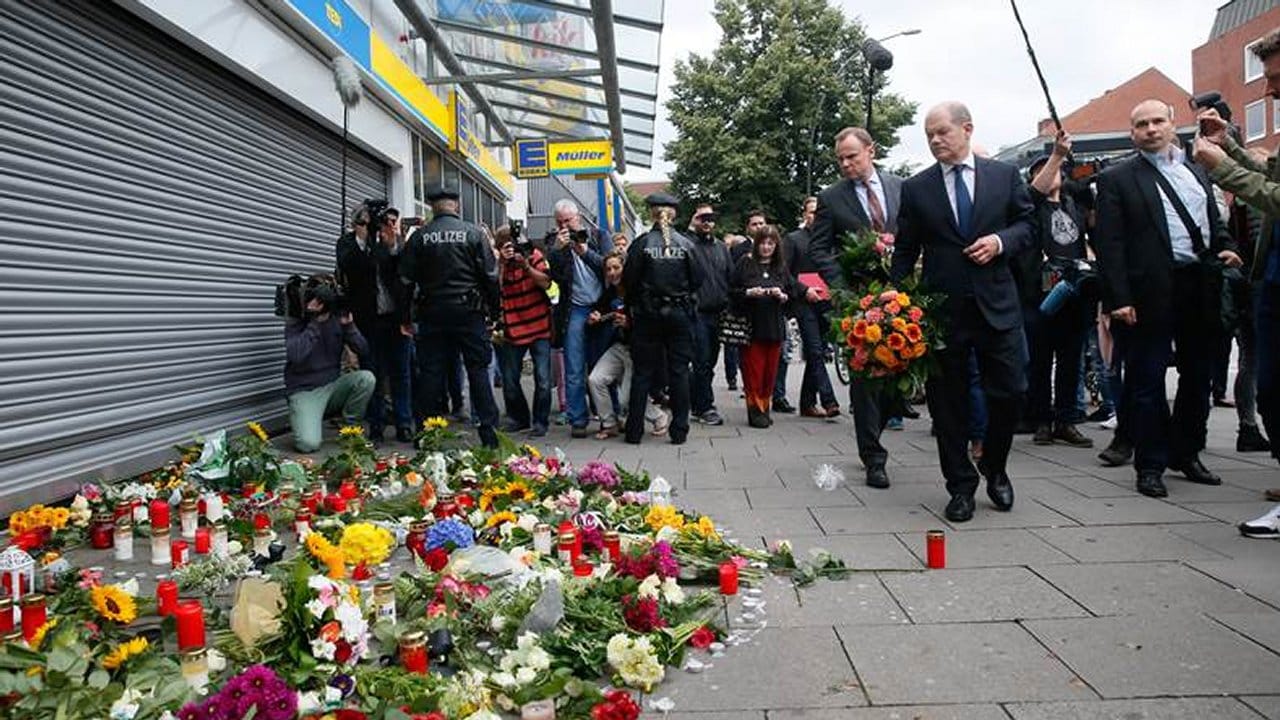 Hamburgs Erster Bürgermeister Scholz und Innensenator Grote kommen in Hamburg-Barmbek mit Blumen zu dem Supermarkt, in dem ein Mann einen Menschen mit einem Messer getötet und sechs weitere verletzt hat. Hamburgs Erster Bürgermeister Scholz und Innensenator Grote kommen in Hamburg-Barmbek mit Blumen zu dem Supermarkt, in dem ein Mann einen Menschen mit einem Messer getötet und sechs weitere verletzt hat.