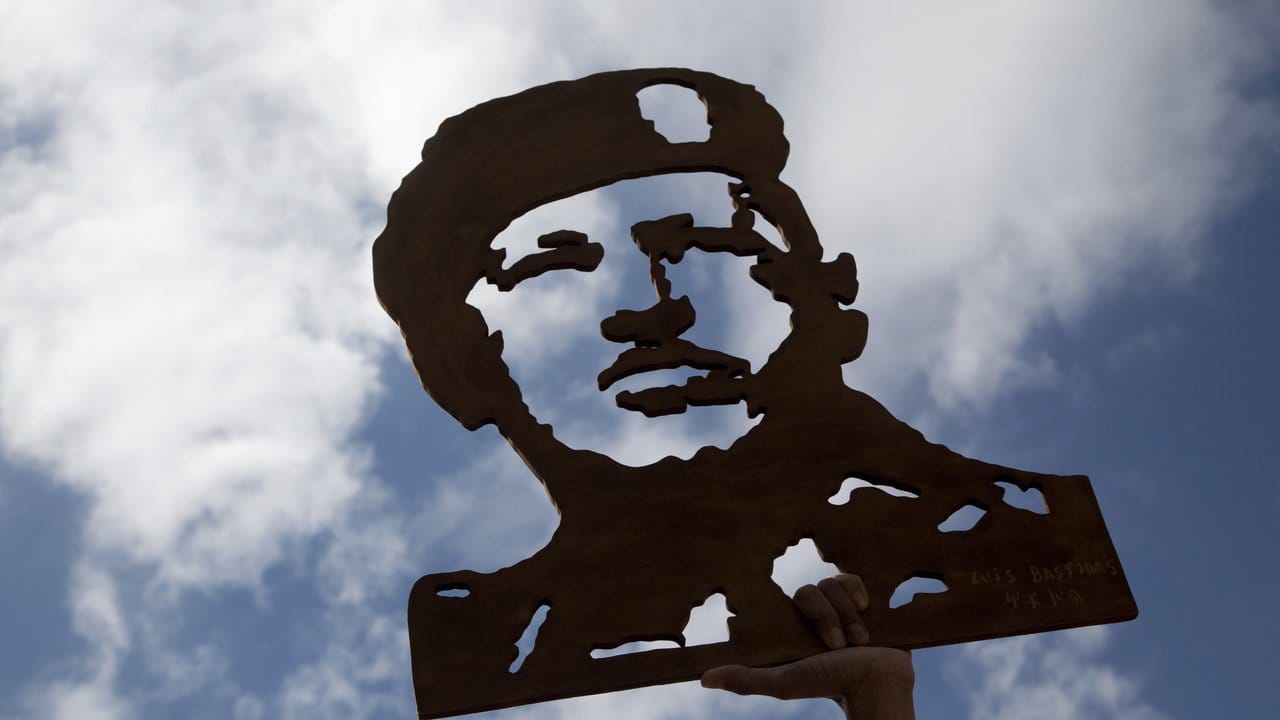 Eine Abbildung des verstorbenen Präsidenten Hugo Chavez wird von einer Demonstrantin in Caracas hochgehalten.