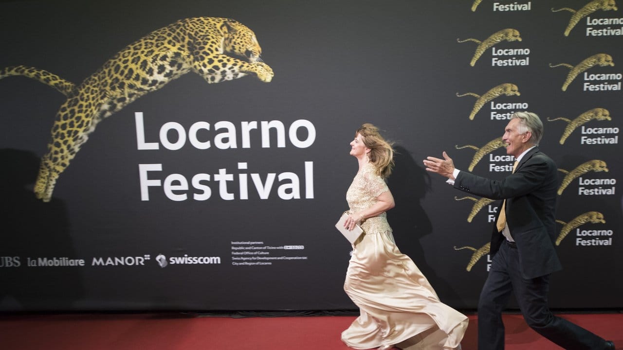 Die deutsche Schauspielerin Nastassja Kinski rennt mit dem Festivalpräsidenten Marco Solari über den roten Teppich.
