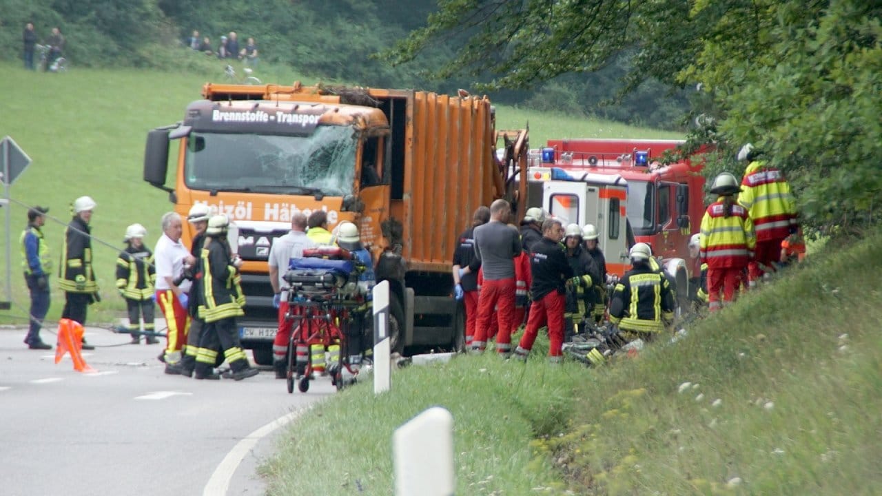 Feuerwehrkräfte arbeiten auf einer Straße bei Nagold an einer Unfallstelle, an der ein Müllwagen auf ein Auto gekippt war. Feuerwehrkräfte arbeiten auf einer Straße bei Nagold an einer Unfallstelle, an der ein Müllwagen auf ein Auto gekippt war.