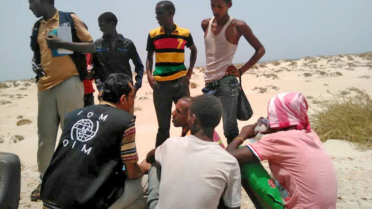 Sie haben überlebt: Ein Mitarbeiter der Internationalen Organisation für Migration kniet neben Flüchtlingen, die von Schleppern ins Meer geworfen worden waren.