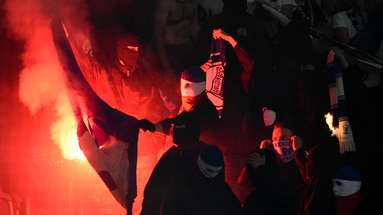 Rostocker Hooligans zünden Stadionsitze und ein Banner der Berliner an.