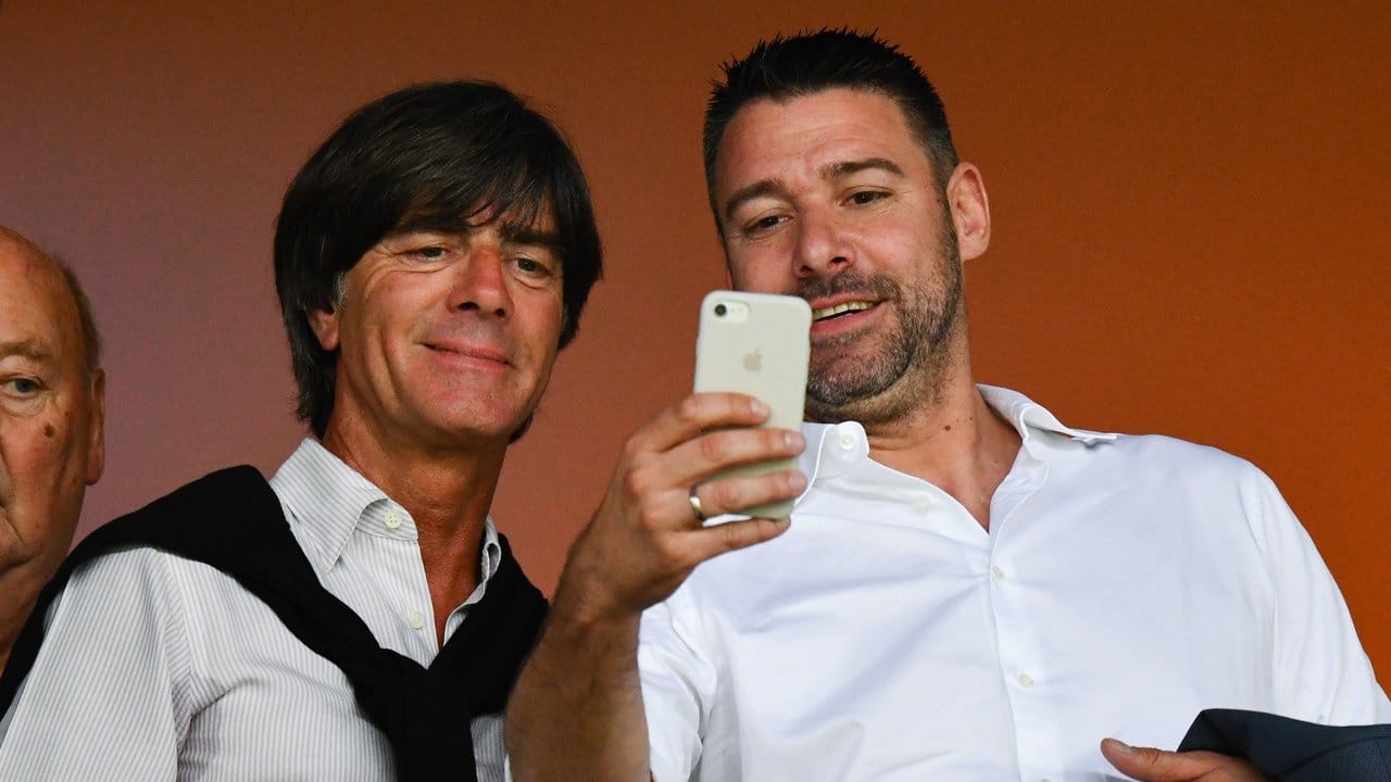 Bundestrainer Joachim Löw (l) posiert bereitwillig auf der Tribüne für ein Selfie.