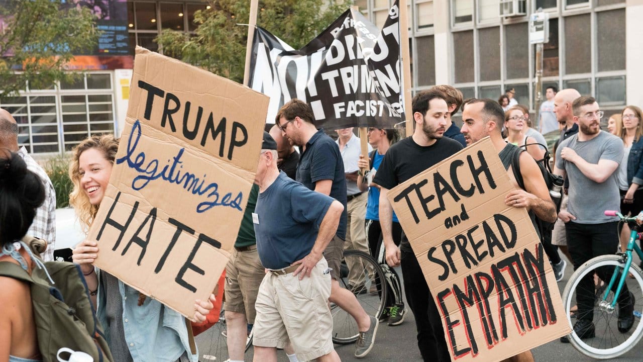 Menschen protestieren in Philadelphia mit Slogans wie "Trump legitimiert Hass" und "Lehre und verbreite Empathie".