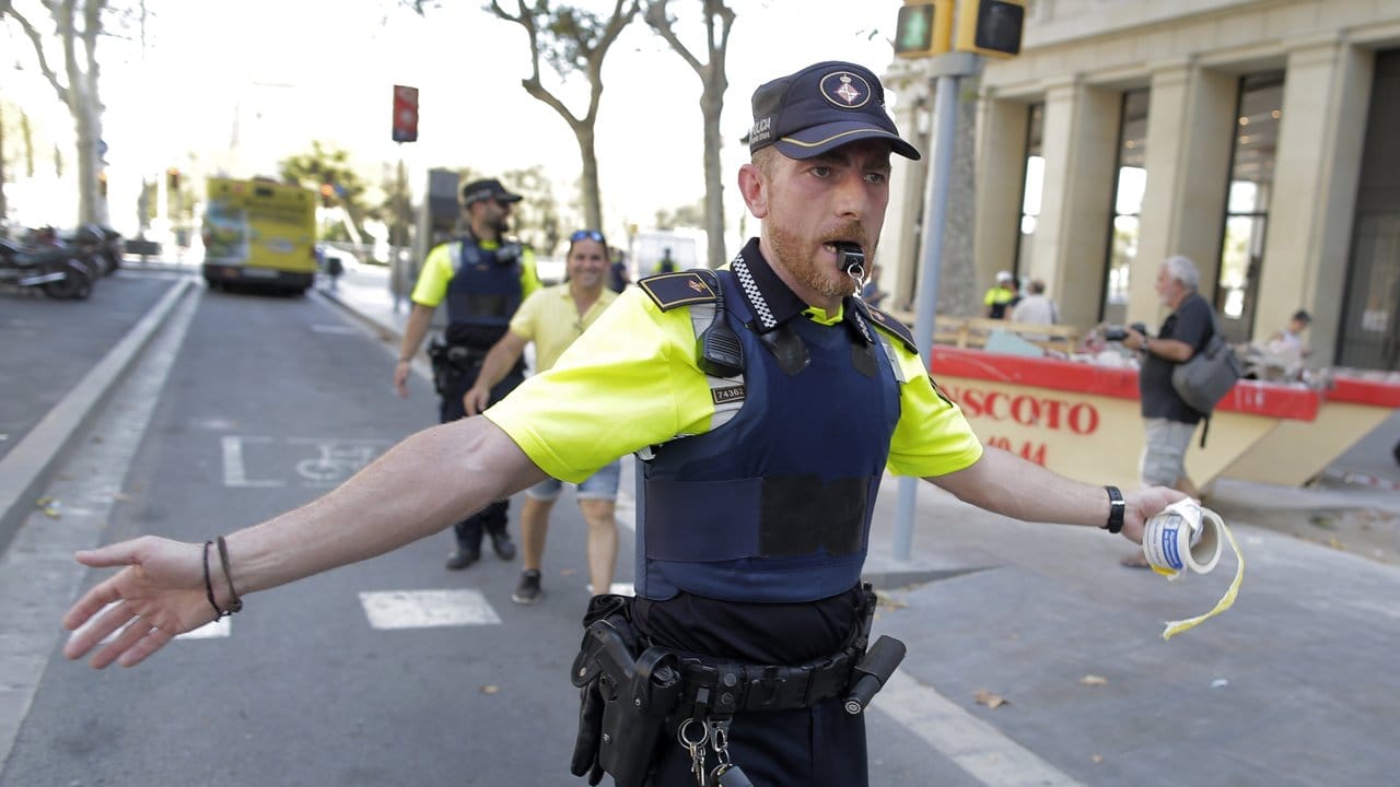 Ein Polizist sperrt in Barcelona eine Straße ab, nachdem ein Lieferwagen auf einer belebten Einkaufstraße in eine Menschenmenge gerast ist.