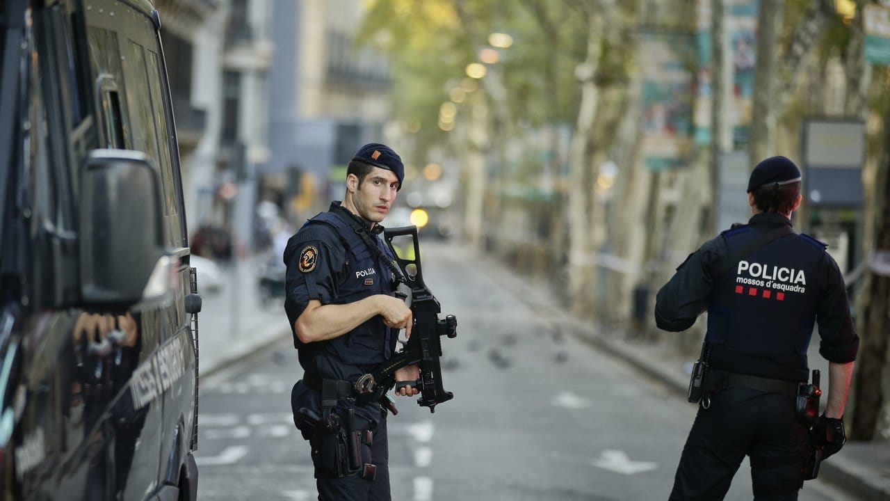 Polizisten sichern den Bereich auf der Flaniermeile Las Ramblas, auf dem der Lieferwagen in eine Menschenmenge gefahren war.