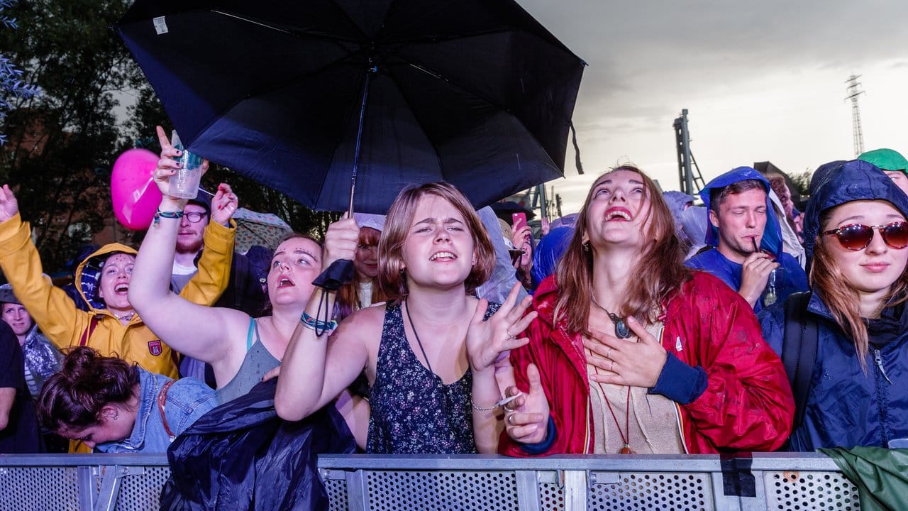 Besucher des Dockville-Festivals im strömenden Regen.