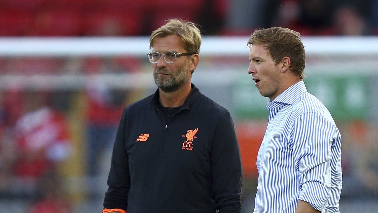 Liverpools Trainer Jürgen Klopp (l) und Hoffenheims Trainer Julian Nagelsmann sprechen vor dem Spiel miteinander.
