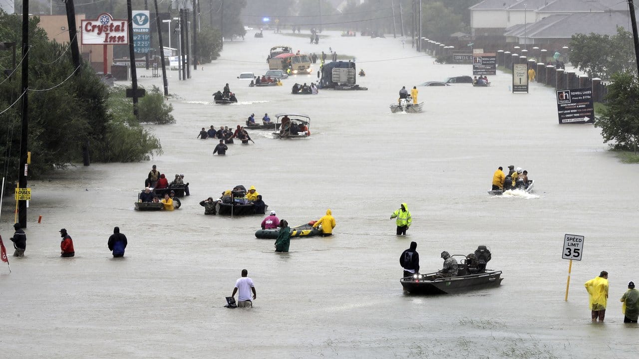 Auf einer überfluteten Straße in Houston werden Boote zur Evakuierung von Flutopfern eingesetzt. Auf einer überfluteten Straße in Houston werden Boote zur Evakuierung von Flutopfern eingesetzt.