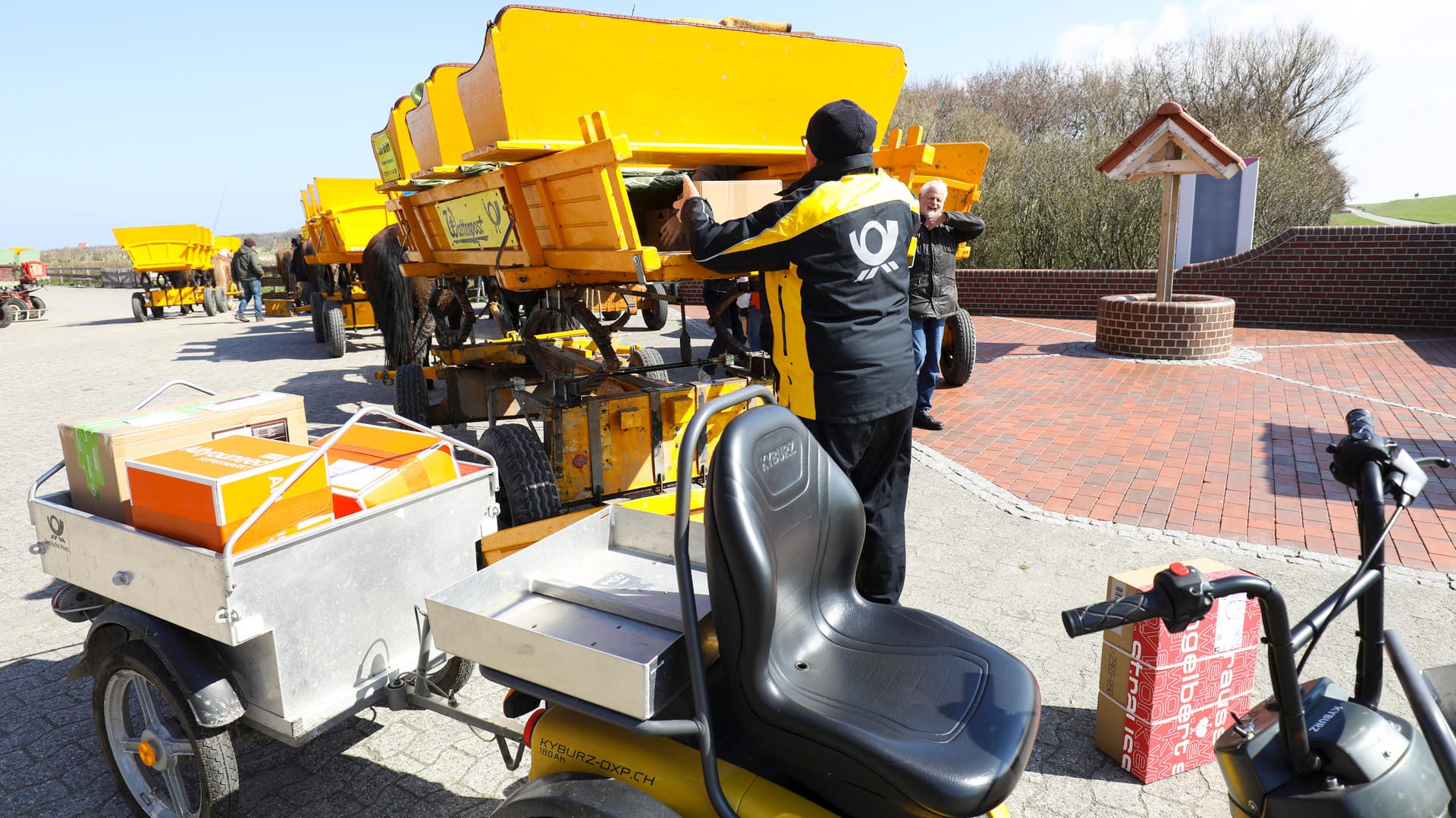 Postkutsche: Postbote Michael Stobbe packt auf der Insel Neuwerk (Hamburg) die Inselpost von der Wattkutsche auf sein Elektrofahrzeug. Schon seit über 20 Jahren gibt es auf Neuwerk keine eigene Poststelle mehr, seitdem pendelt ein Zusteller im Winter bis zu drei Mal und im Sommer bis zu sechs Mal die Woche zwischen der Insel und Cuxhaven (Niedersachsen).