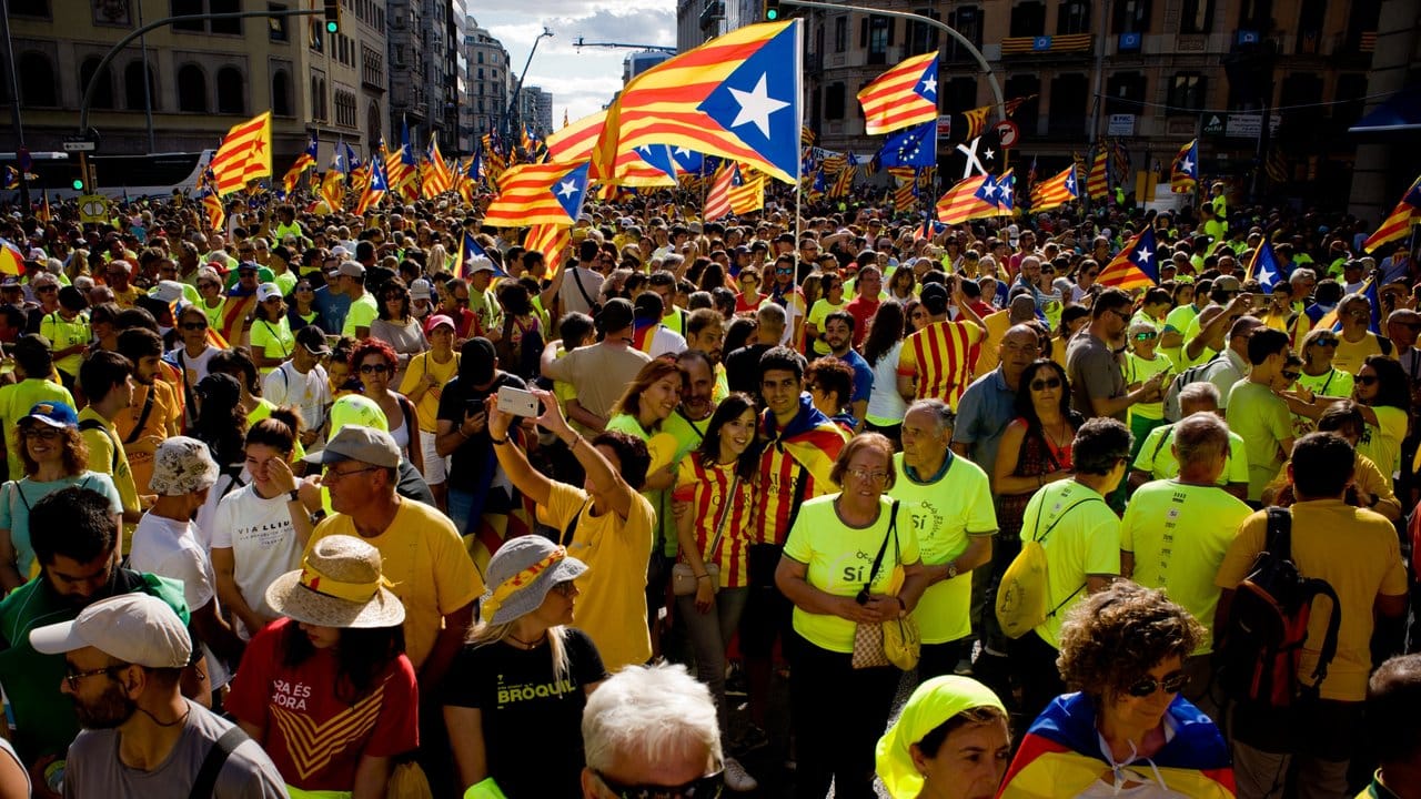 Demonstranten tragen in Barcelona katalonische Flaggen durch die Straßen.