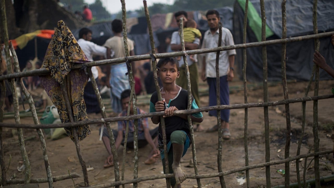 Ein Rohingya-Kind steht im bangladeschischen Ukhia an einem Holzzaun im Flüchtlingslager Kutupalong, nachdem es kurz zuvor die Grenze von Myanmar nach Bangladesch überquert hat.