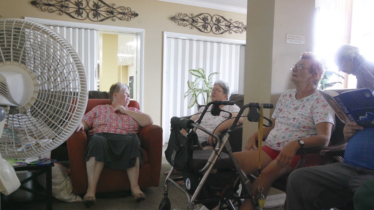 Bewohner eines Seniorenwohnheims sitzen in Clearwater, Florida, USA, in einem Gemeinschaftsraum vor Ventilatoren.