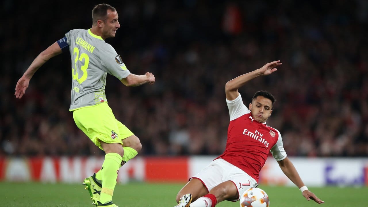 Arsenals Alexis Sanchez (r) versucht den Kölner Kapitän Matthias Lehmann vom Ball zu trennen. Arsenals Alexis Sanchez (r) versucht den Kölner Kapitän Matthias Lehmann vom Ball zu trennen.