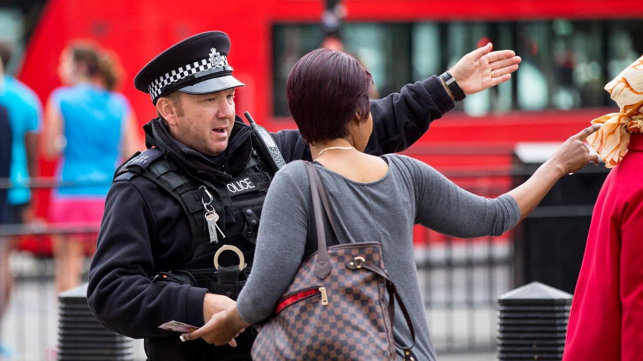 Eine Passantin holt sich in London bei einem Polizisten Rat. Eine Passantin holt sich in London bei einem Polizisten Rat.