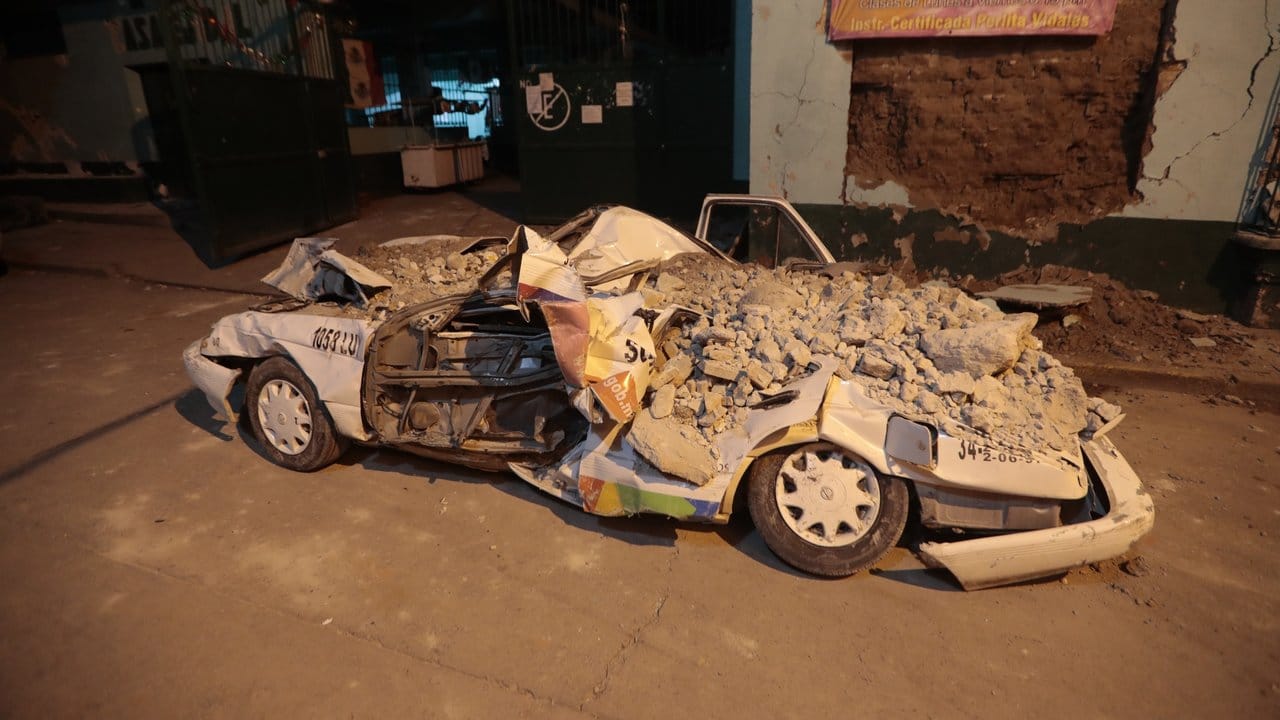 Ein Auto steht in Jojutla von Schutt bedeckt auf der Straße. Ein Auto steht in Jojutla von Schutt bedeckt auf der Straße.