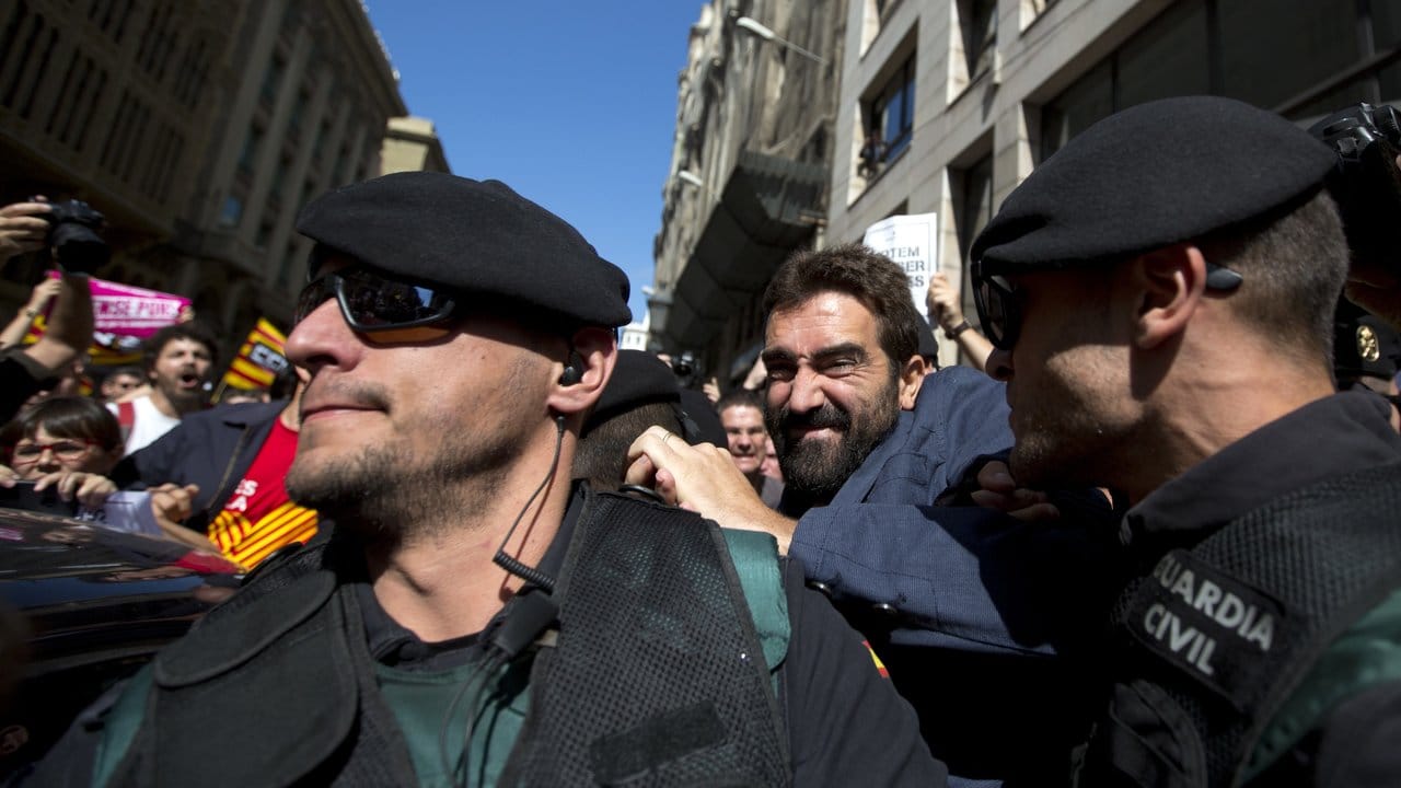 Beamte der paramilitärischen Polizeieinheit Guardia Civil nehmen in Barcelona Xavier Pug fest, der für die katalanische Regionalbehörde arbeitet. Beamte der paramilitärischen Polizeieinheit Guardia Civil nehmen in Barcelona Xavier Pug fest, der für die katalanische Regionalbehörde arbeitet.