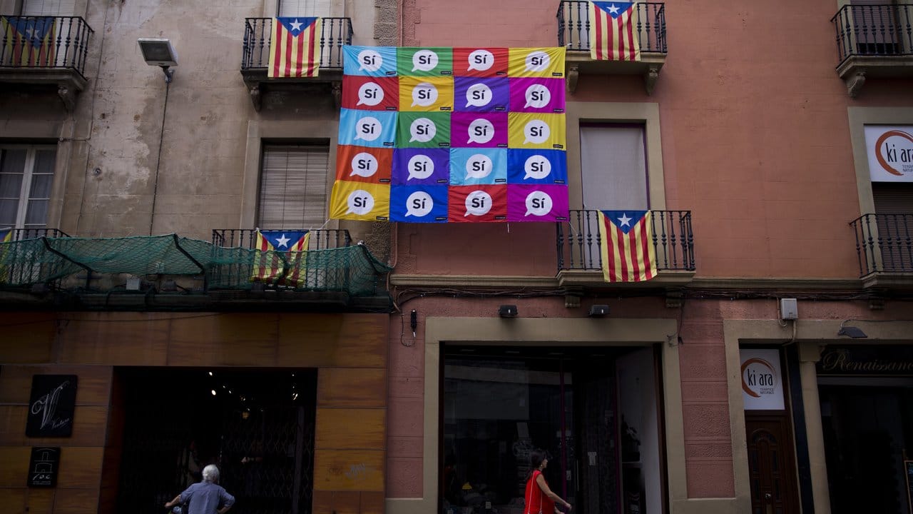 Eine mit Unabhängigkeits-Flaggen und "Si"-Bannern dekorierte Hauswand in Sabadell. Eine mit Unabhängigkeits-Flaggen und "Si"-Bannern dekorierte Hauswand in Sabadell.