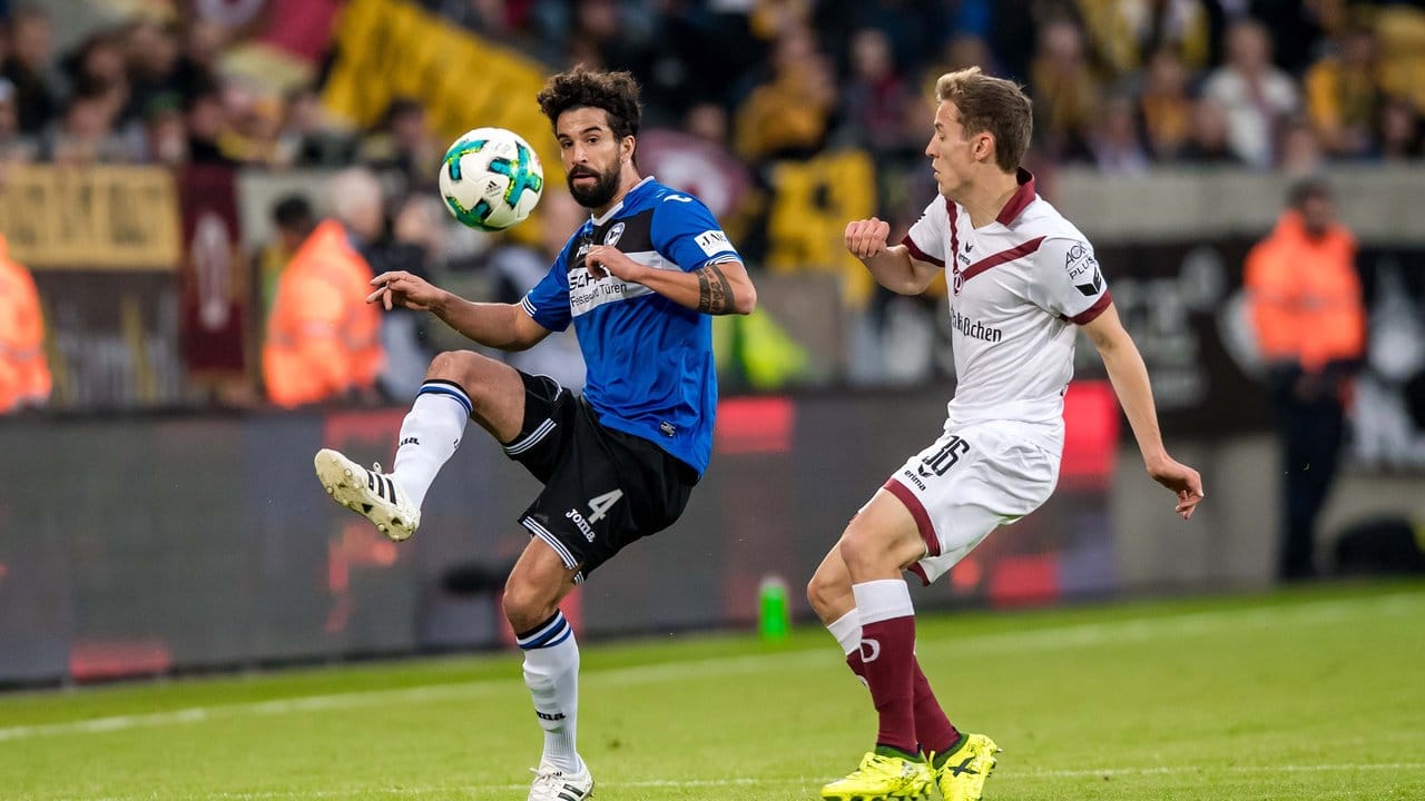Bielefelds Nils Teixeira (l) kommt vor Niklas Hauptmann von Dynamo Dresden an den Ball.