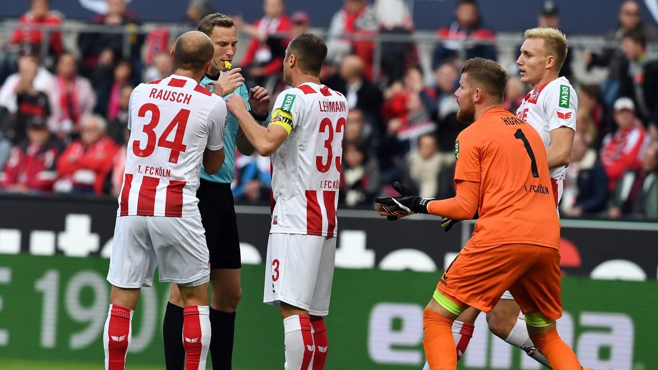 Kölns Spieler mit Torwart Timo Horn protestieren bei Schiedsrichter Martin Petersen gegen den Elfmeter.
