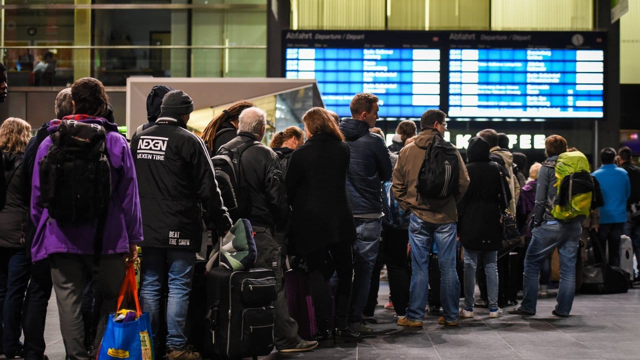 Fahrgäste stehen auf dem Hauptbahnhof in Berlin an einem Informationsschalter der Deutschen Bahn an.