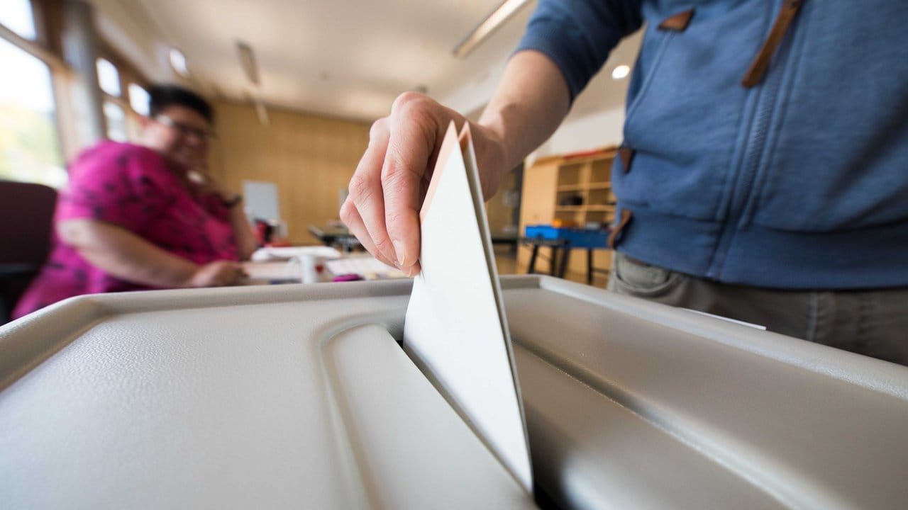 Ein Mann wirft bei der Bundestagswahl seinen Stimmzettel in Frankfurt am Main in eine Wahlurne.