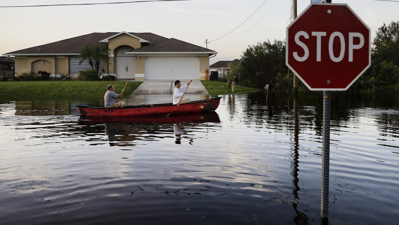 Zwei Männer paddeln durch eine überflutete Nachbarschaft in Fort Myers. Mit Urgewalt war Hurrikan "Irma" über Florida hinweggezogen.