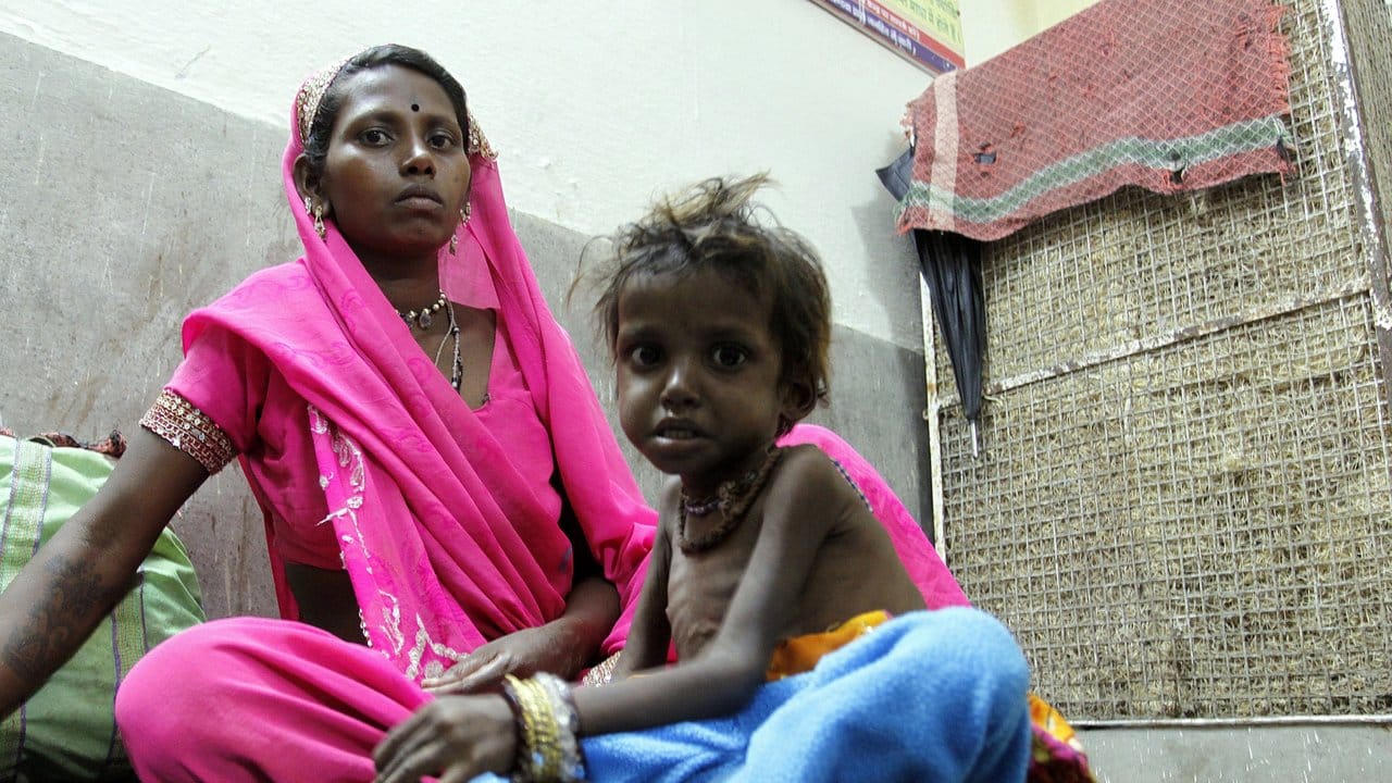 Eine indische Mutter sitzt mit ihrem unternernährten Kind in ihrer Wohnung in Bhopal. Eine indische Mutter sitzt mit ihrem unternernährten Kind in ihrer Wohnung in Bhopal.