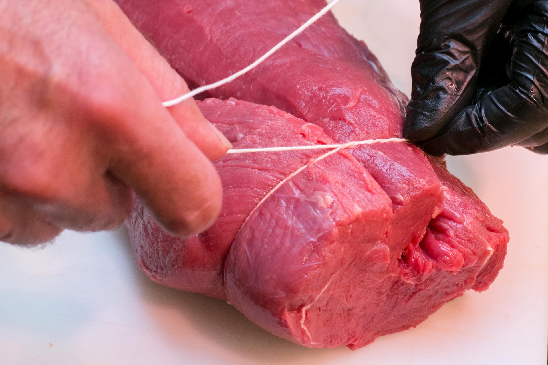 Schritt 5: Um das Fleisch in Form zu bringen, braucht man Küchengarn. Damit das Fleisch in mehreren Schritten zusammenschnüren.