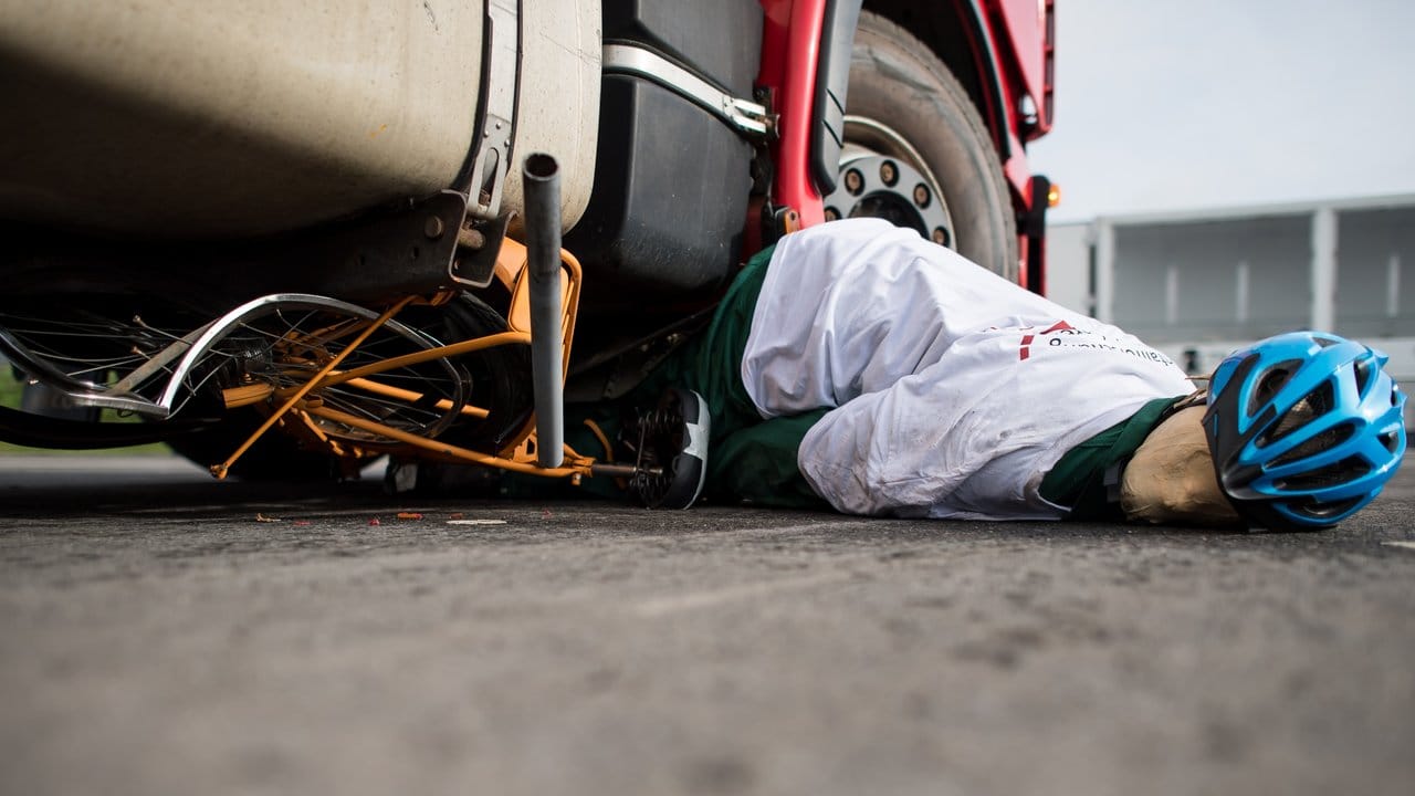 Ein Radfahrer-Dummy liegt bei dem Crash-Test in Münster unter einem Lastwagen. Ein Radfahrer-Dummy liegt bei dem Crash-Test in Münster unter einem Lastwagen.