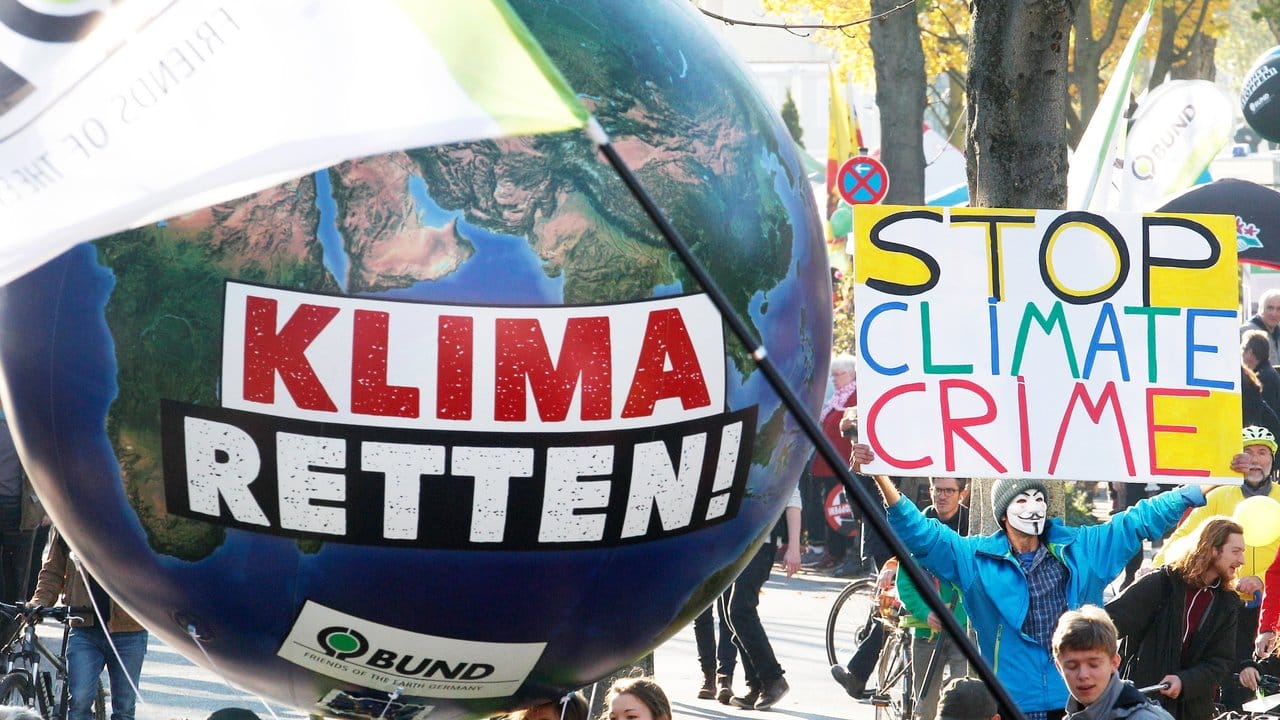 Demonstranten fordern in Bonn mit einem Modell der Erdkugel die Umsetzung des Weltklimaabkommens.