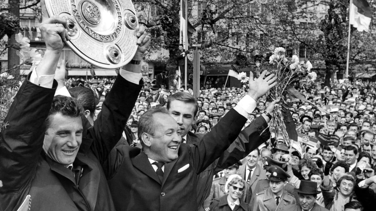 FC-Kapitän Hans Schäfer (l) jubelt 1962 mit der Meisterschale über den Gewinn der Deutschen Fußball-Meisterschaft in Köln; neben ihm Trainer Zlatko "Tschik" Cajkovski (2.