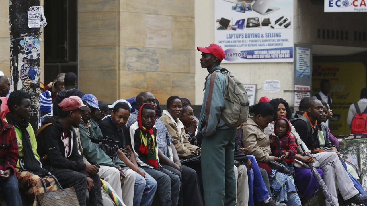 Menschen warten in Harare vor einer Bank, um Bargeld abzuheben.