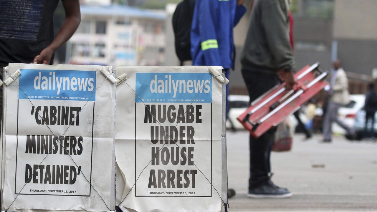 "Mugabe unter Hausarrest": Junge Männer passieren in Harare ausgestellte Zeitungstitel. "Mugabe unter Hausarrest": Junge Männer passieren in Harare ausgestellte Zeitungstitel.