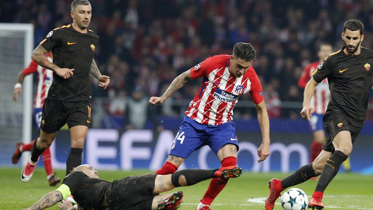 Jose Maria Gimenez (M) von Atletico Madrid Kampf um den Ball gegen zwei Spieler von AS Rom.