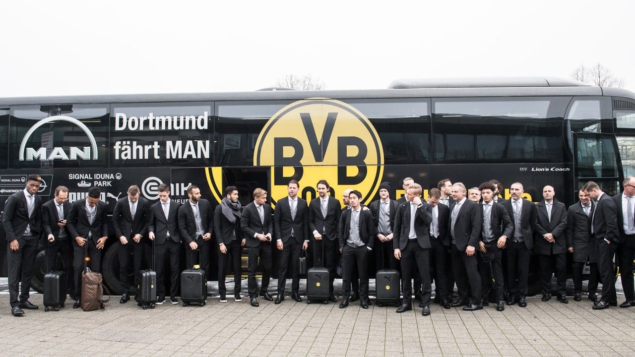 Die Spieler des BVB sammeln sich am Flughafen in Dortmund vor dem Abflug am Mannschaftsbus zu einem Gruppenfoto.