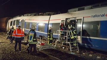 Feuerwehrleute stehen an einem verunglückten Personenzug in Meerbusch (Nordrhein-Westfalen).