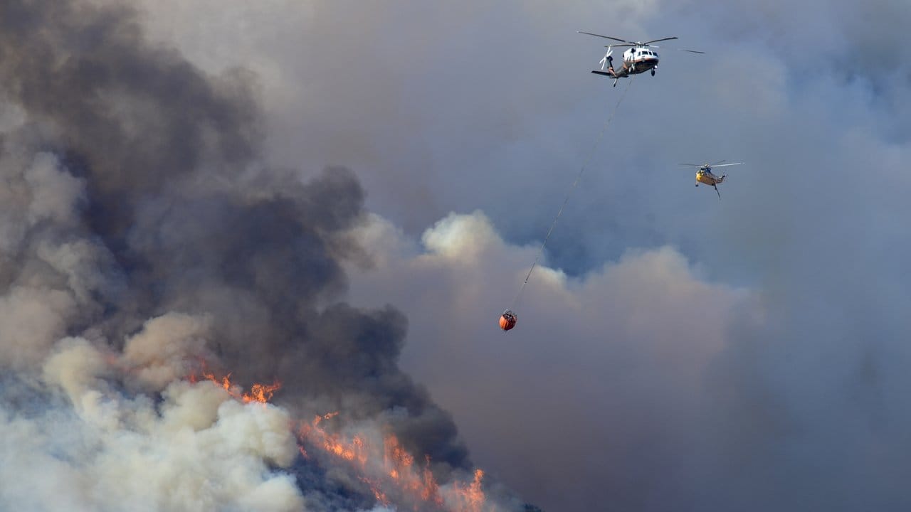 Mit Hilfe von Helikoptern werden bei La Canada die Buschbrände bekämpft.