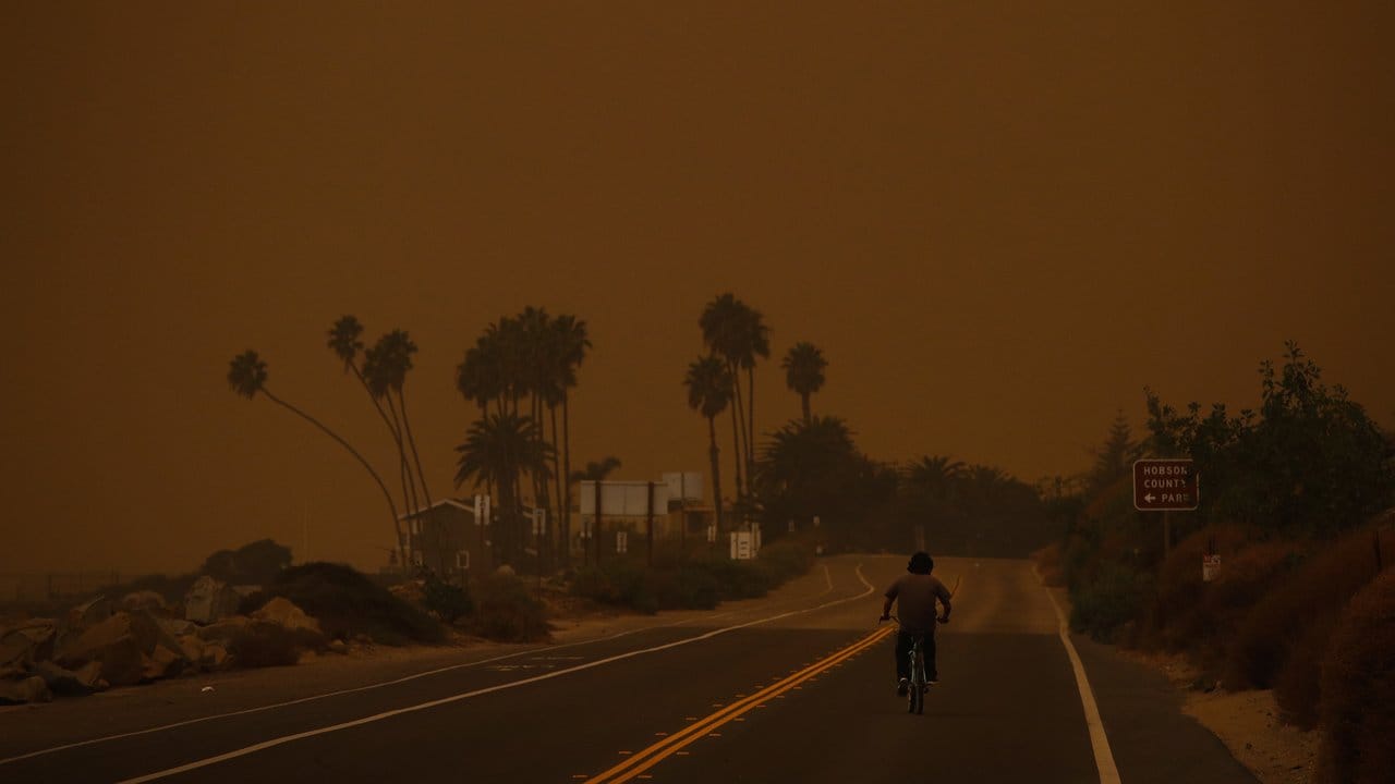 Dichter Rauch: Ein Fahrradfahrer fährt den Pacific Coast Highway entlang.