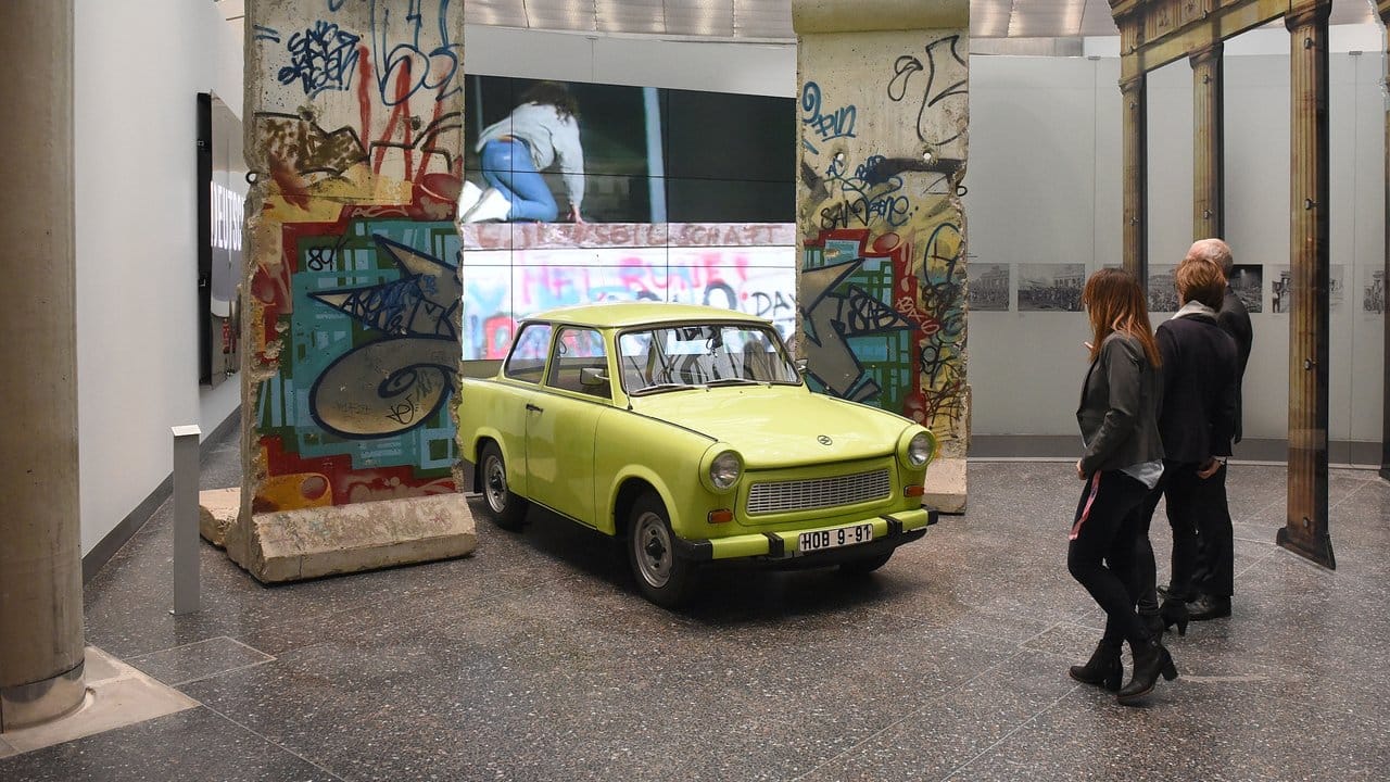 Teile der Berliner Mauer und ein gelb-grüner Trabant im Haus der Geschichte in Bonn.