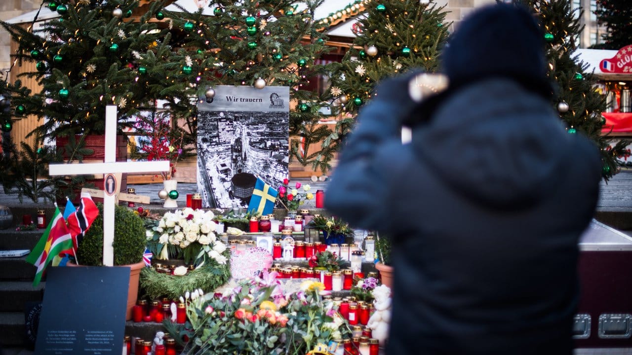 Ein Mann macht ein Foto der provisorischen Gedenkstätte für die Opfer des Anschlags vom Breitscheidplatz in Berlin. Ein Mann macht ein Foto der provisorischen Gedenkstätte für die Opfer des Anschlags vom Breitscheidplatz in Berlin.
