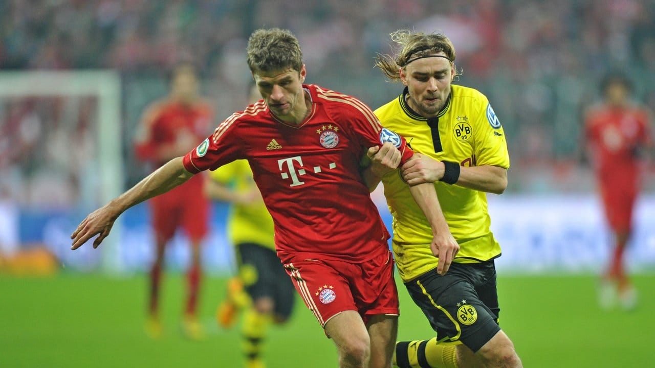 Münchens Thomas Müller (l) im Kampf um den Ball mit BVB-Spieler Marcel Schmelzer. Münchens Thomas Müller (l) im Kampf um den Ball mit BVB-Spieler Marcel Schmelzer.