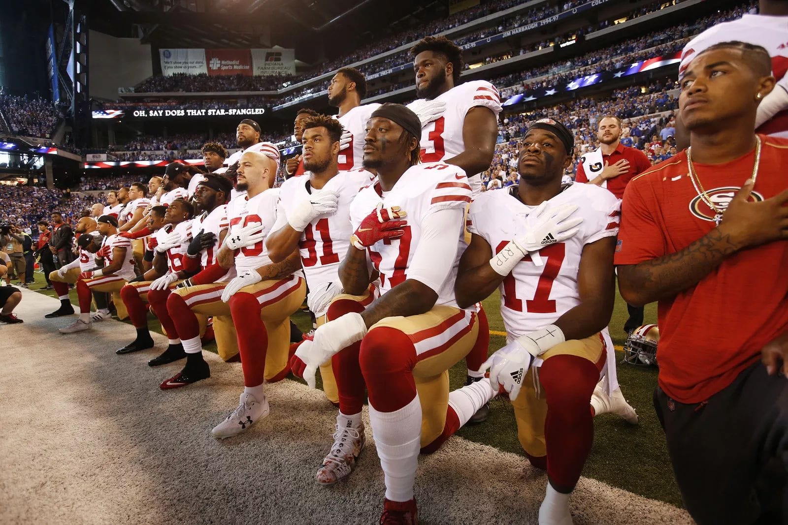 Symbolischer Kniefall: Spieler der Football-Mannschaft San Francisco 49ers knien in Indianapolis während der US-Hymne nieder - aus Protests gegen rassistische Ausschreitungen.